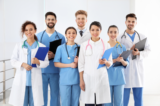 Eine Gruppe junger Medizinier mit Klemmbrettern lächelt in die Kamera